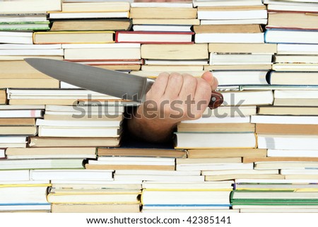 big kitchen  knife in hand on background of books
