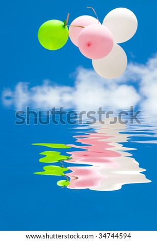 Balloons in the blue sky. Reflected in Water.