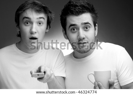 Two young men watching TV. Black and White
