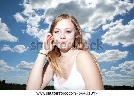 Young girl against cloudy blue sky