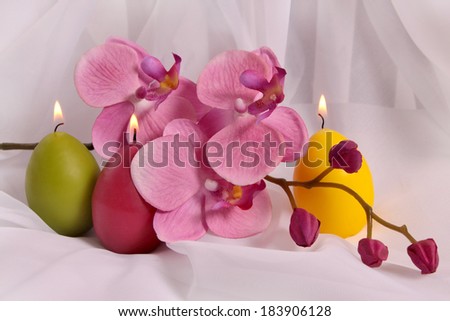 candles were lit near the flower is all on white fabric