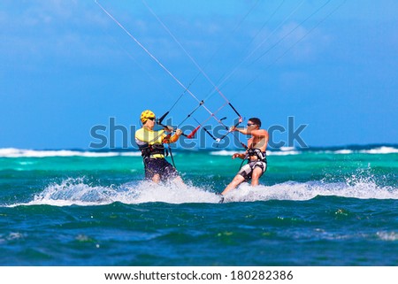 two kite surfers going towards each other on tropical sea background Extreme Sport Kite surfing