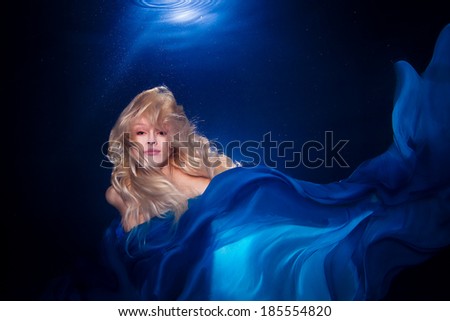 underwater photo pretty young girl  with blond long hair wearing blue fabric