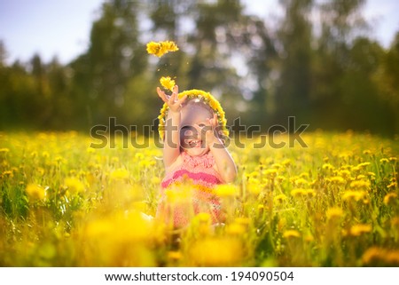 Image of happy child on dandelions field, cheerful little girl resting on dandelions meadow, relaxation outdoor in springtime, vacation.