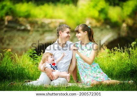 Happy family, mom, dad and little son having fun in the park. Summer vacations concept.
