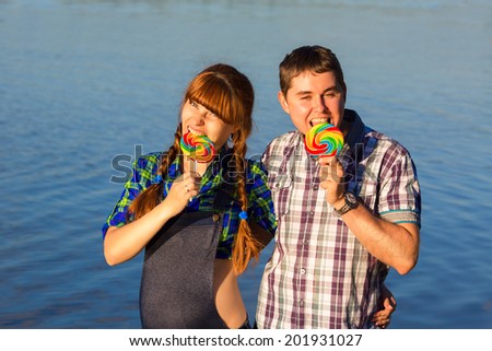 Happy and young pregnant couple having fun on the beach. Summer vacation. New life concept. Future mother and father.
