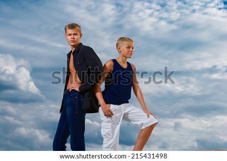 Two teenagers on the beach. Looks thoughtfully into the distance. The sky in the background. Summer vacation concept.