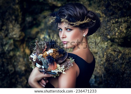 Young beautiful girl with a wreath in the sea theme, holding a bouquet of sea urchins.
