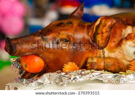 Decorated and roast suckling pig on a table on banquet. Filipino dishes Lechon.