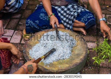 Bali, Indonesia, May 3, 2015. Unidentified balinese men prepare a meal for the feast at the local temple in Bali, Indonesia.