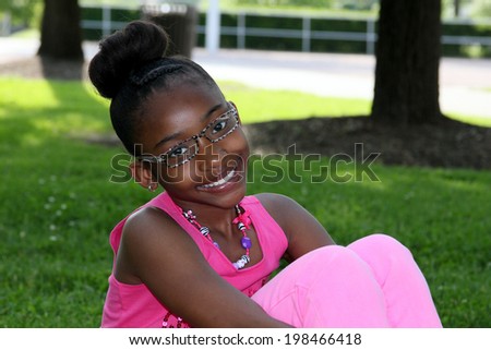 Pretty young African American girl with cute bun and glasses
