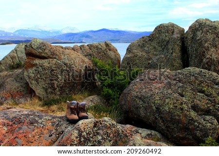 Hiking shoes on boulders with lake and mountains in background