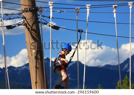 VAIL, COLORADO - July 3, 2015 - Young girl practicing rope and climbing skills on a challenge course