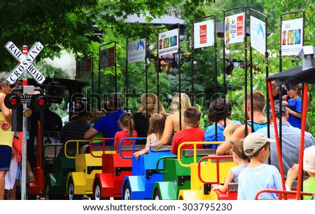 GOLDEN, COLORADO - July 26, 2015 - Colorful train with children and parents at the railroad crossing sign