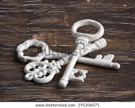 Pile of antique keys, white, on wood background