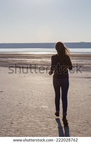 Silhouette of a girl on a background of a sunset on the banks of the river, the sea, ocean