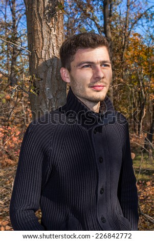 Young handsome man on a walk in the autumn forest