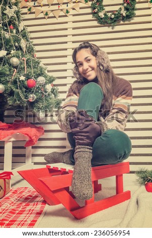 Beautiful and happy girl with gifts near a Christmas tree wishes everyone a Merry Christmas and Happy New year