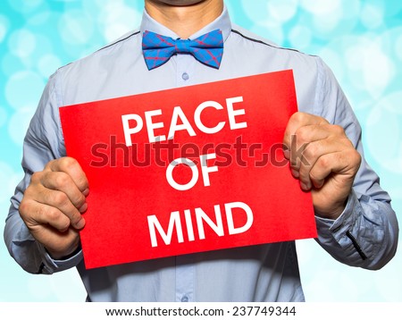 Man holding a card with the text Peace of mind on white background