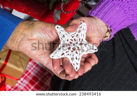 Hands of an senior man and woman holding star pf Christmas