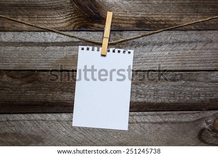 Message written on a paper hanging on the clothesline on wooden background