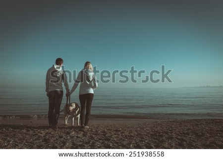 Lovers walk along the shore of a tropical beach with a dog. Book cover