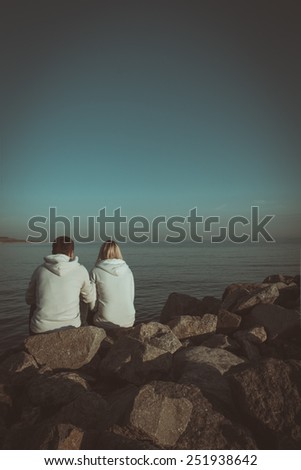Loving couple sitting on the sea shore. Book cover