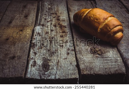 Croissant for breakfast on the vintage wooden background