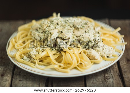 Fettuccine with chicken and cream sauce on a wooden vintage background