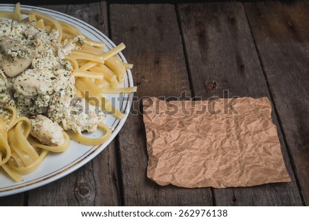 Fettuccine with chicken and cream sauce on a wooden vintage background
