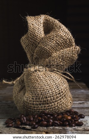 Coffee beans with package on the wooden vintage table and place for text