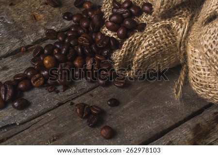 Coffee beans with package on the wooden vintage table and place for text