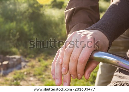 Lovers man and woman riding on a vintage bike and holding hands
