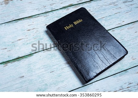 Black Holy Bible on white vintage wooden background
