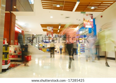 people\'s motion blur in busy shopping mall
