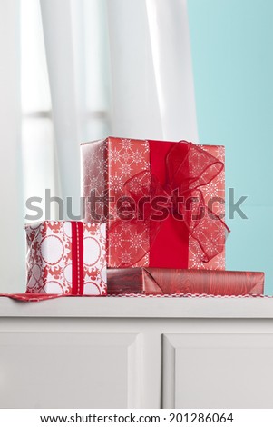 Presents on dresser in front of a window inside a home. Shot with copy space.