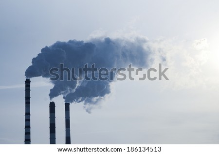 Smoke emission from factory pipes on blue sky