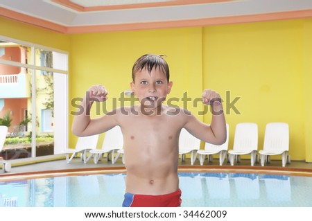 young boy pulling a funny face in pool