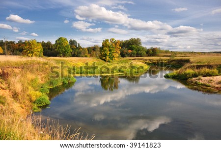 Picturesque autumn landscape of river with bright trees and bushes