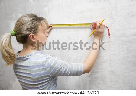 worker woman measuring on wall straightedgetape measure