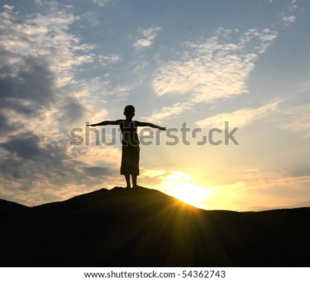 young man go up in sand desert in sundown silhouette