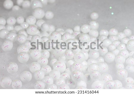 White little balls of polyester with glitter on bright background.Christmas concept