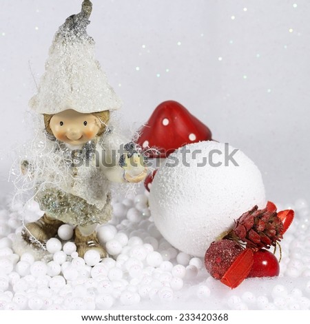 Cute elf girl smiling,holding a little bird in her hand,standing in the snow,in the forest