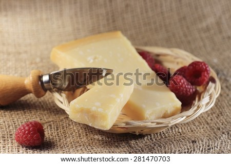 Parmesan cheese and slice in a basket, special little knife for parmesan,on natural jute tablecloth