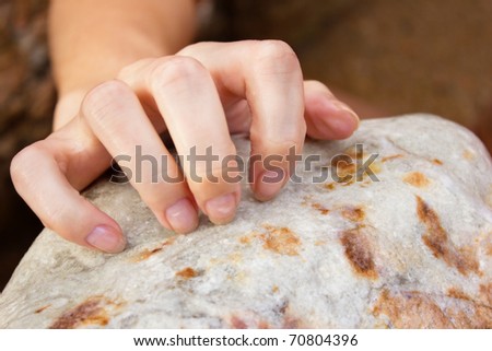 Cropped image of a female hand scratching on the stone - Outdoor