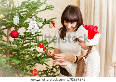 Family decorates at Christmas tree at home