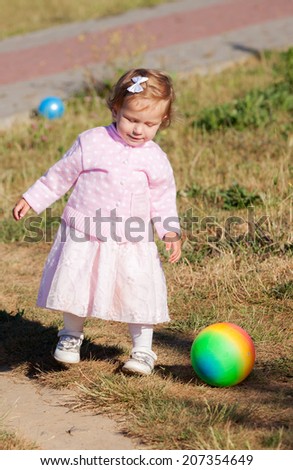 little girl with a ball in park