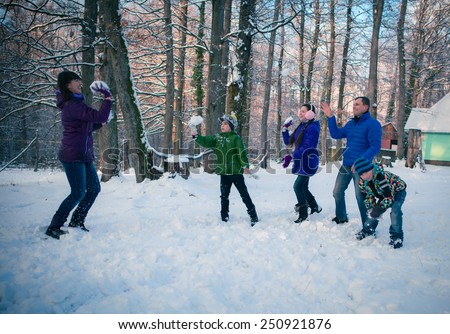 Family having snowball fight in snow in winter background
