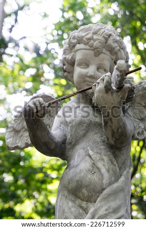 Decorative cupid playing violin sculpture in the garden