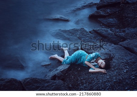 Beautiful young woman on sea in twilight. Long time exposure
